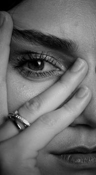Black and white close-up of a woman's face focusing on her eye and rings.