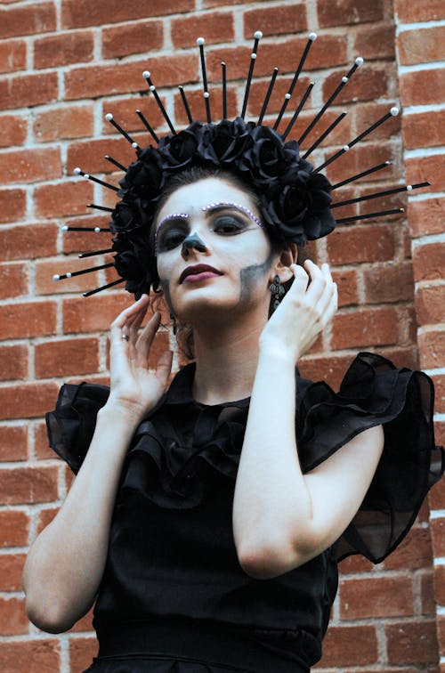 Woman in a Halloween Costume and Makeup Wearing Black Dress and Crown 