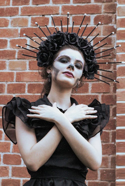 Woman in a Halloween Costume and Makeup Wearing Black Dress and Crown