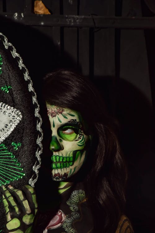 Free Vibrant Day of the Dead makeup featuring intricate designs and sombrero. Stock Photo