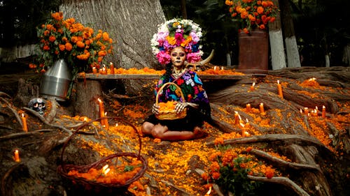 Woman in Traditional Costume Sitting in Forest with Candles and Decoration