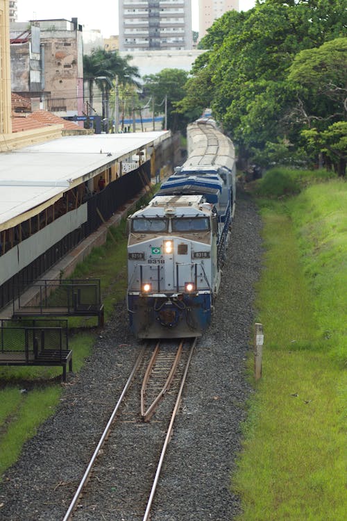 A Train on the Tracks by a Building 