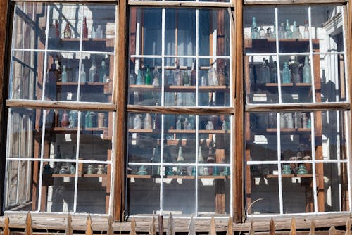 Shelves with Glass Bottles behind the Windows 