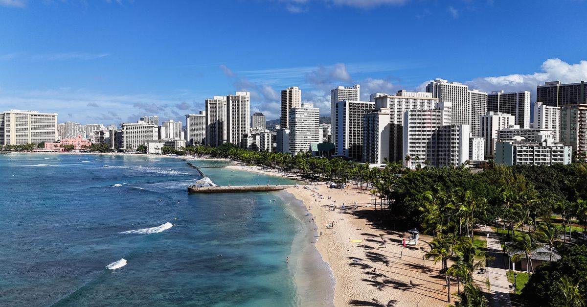 Photo by David Yu Discover the stunning skyline and beachside views of Honolulu's Waikiki Beach.