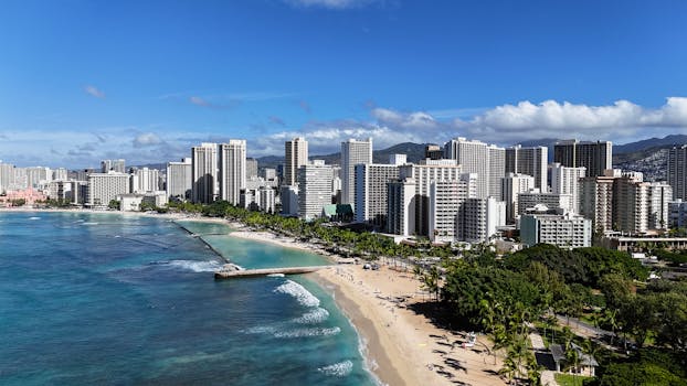 Explore the stunning Waikiki Beach with urban skyline and clear blue waters in Honolulu.