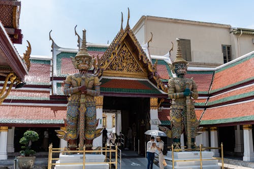 Tourists at Koei Sadet Gate with Suriyaphop and Intarachit Statues at Temple of the Emerald Buddha