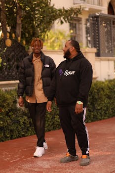 Two fashionable men walking outdoors in Miami Beach during fall.