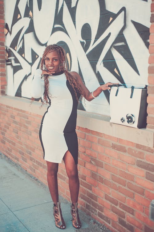 Smiling Woman in Dress Standing by Wall