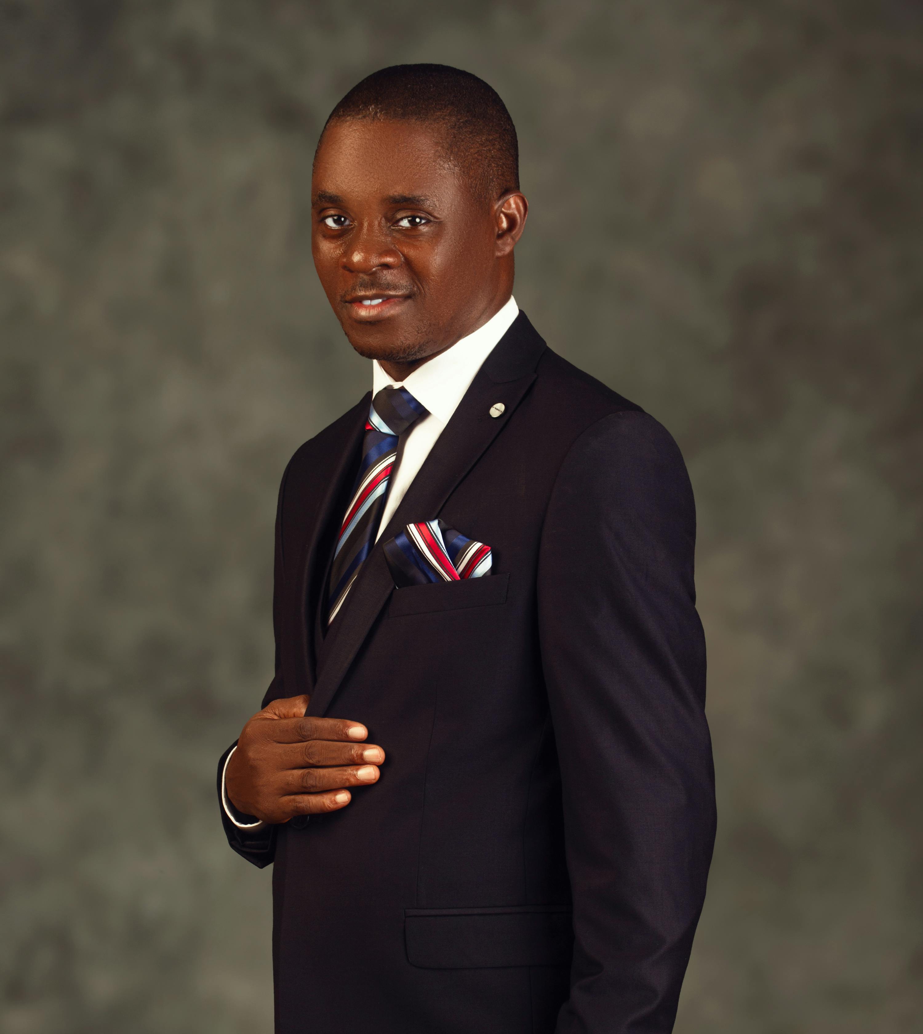 Portrait of a confident man in a blue suit and striped tie, exuding elegance.