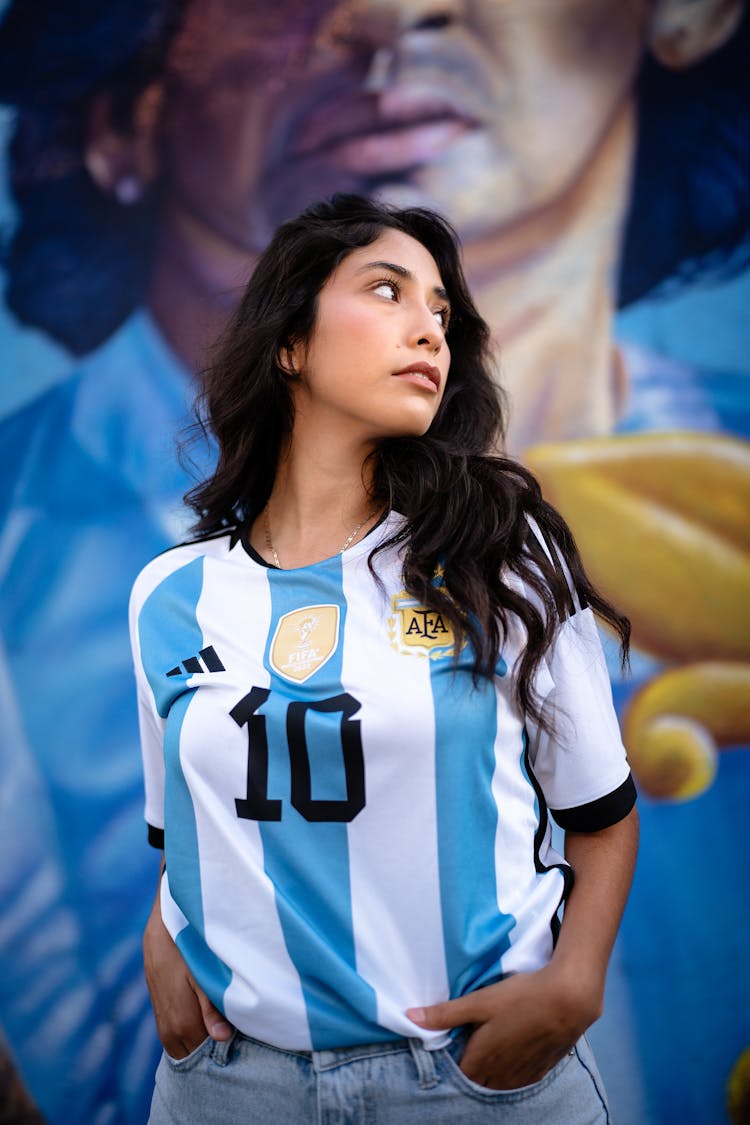 Brunette Woman In Argentinian Football Shirt Holding Hands In Pockets