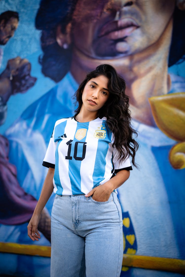 Brunette Woman In Argentinian Football Shirt Holding Hand In Pocket