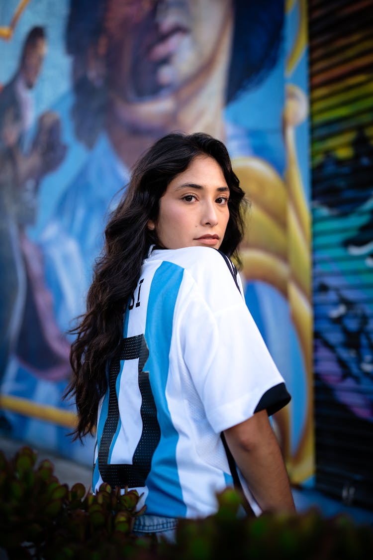 Brunette Woman In Argentinian Football Shirt Looking Back Over Shoulder