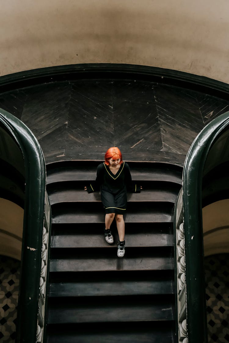 Young Woman Sitting On Old Wooden Stairs In The Museum