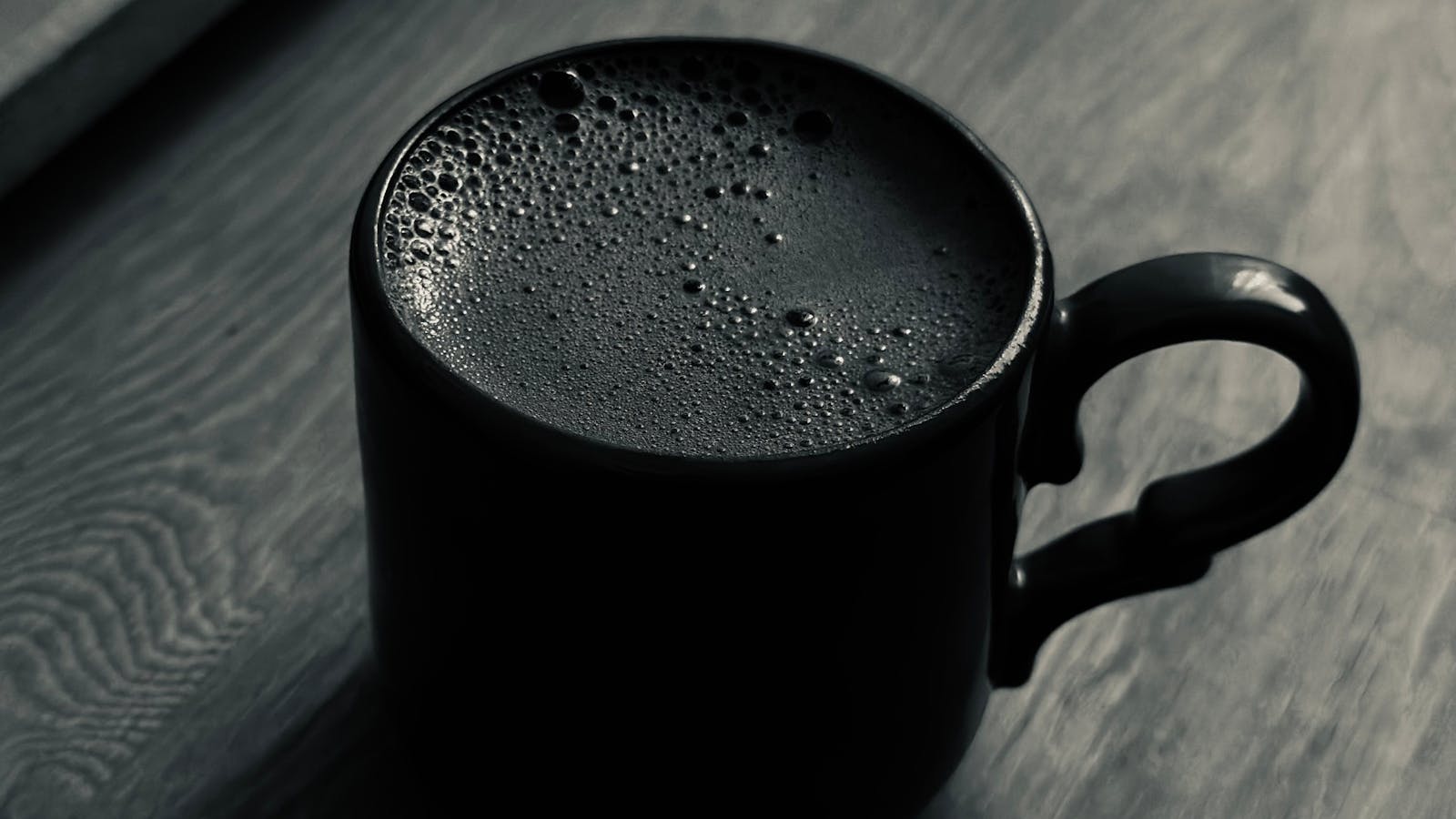 Fresh brewed coffee in a mug on a wooden table