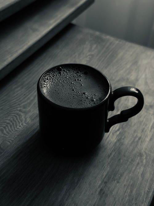 Free A steaming mug of coffee sits on a rustic wooden table, creating a cozy atmosphere. Stock Photo