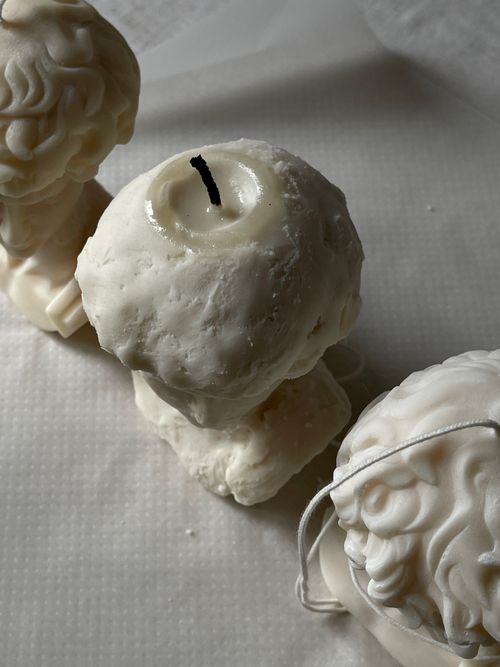 Free Close-up of decorative bust-shaped candles on a white surface, capturing texture and detail. Stock Photo