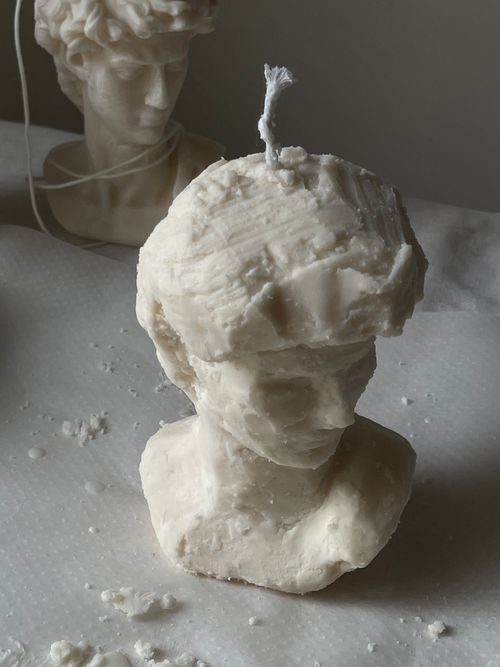 Free Detailed wax sculpture candle resembling a classical bust with rustic texture. Stock Photo