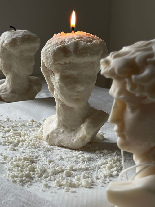 Free Elegant wax busts with burning candle provide an artistic ambiance. Stock Photo