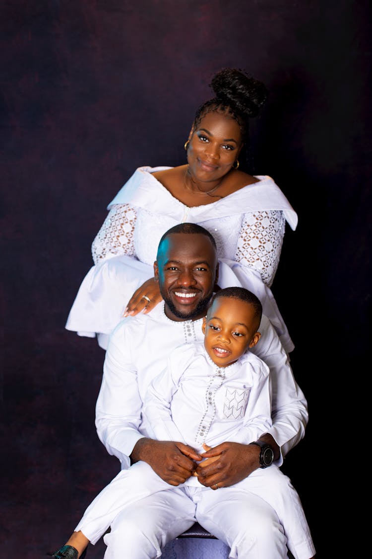 Smiling Mother, Father And Son On Black Background