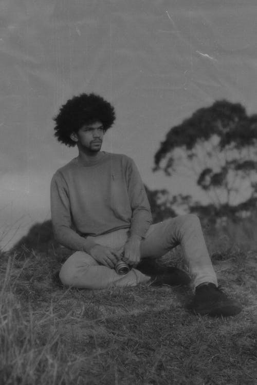 African Man Sitting on a Field in Black and White 