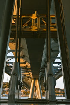 Modern Istanbul bridge architecture viewed from below at sunset, highlighting structural design.