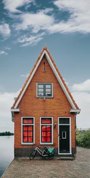 Picturesque brick house by the water in Volendam, showcasing classic Dutch architecture.