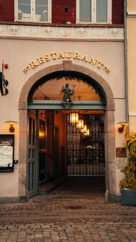 Elegant restaurant entrance in Copenhagen with archway and warm lighting.