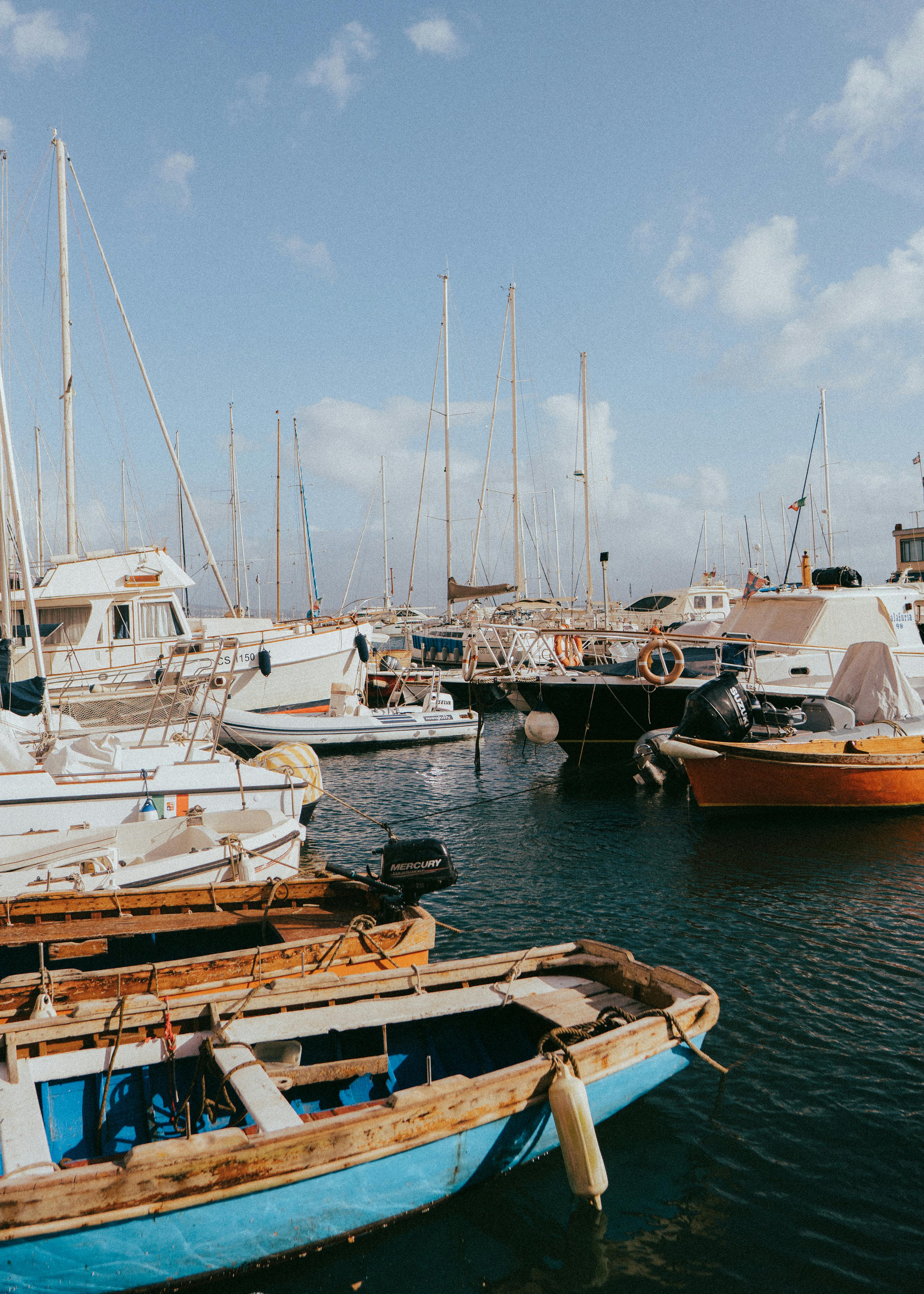 Serene view of boats in a marina under a blue sky in Neapolis, Italy.