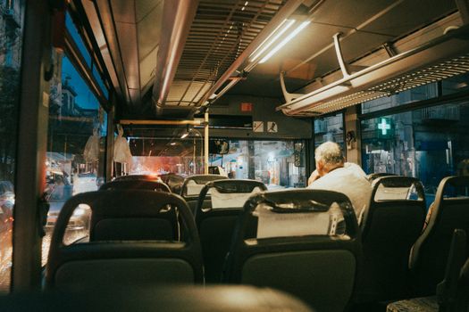 Interior view of a night bus in Neapolis, capturing the city light ambiance through the window.