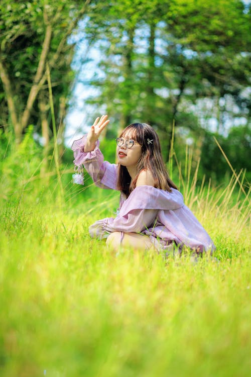 Woman in Eyeglasses Sitting on Grass
