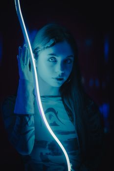 Dramatic portrait of a woman bathed in blue neon light, creating an intense and mysterious atmosphere.