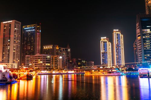 Free Stunning night view of Dubai Marina with illuminated skyscrapers reflecting over the water. Stock Photo