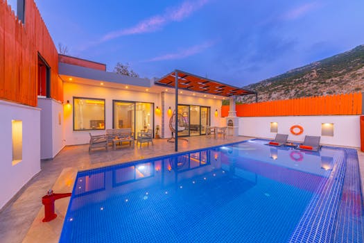 Elegant modern resort featuring a stylish swimming pool under a vibrant twilight sky.