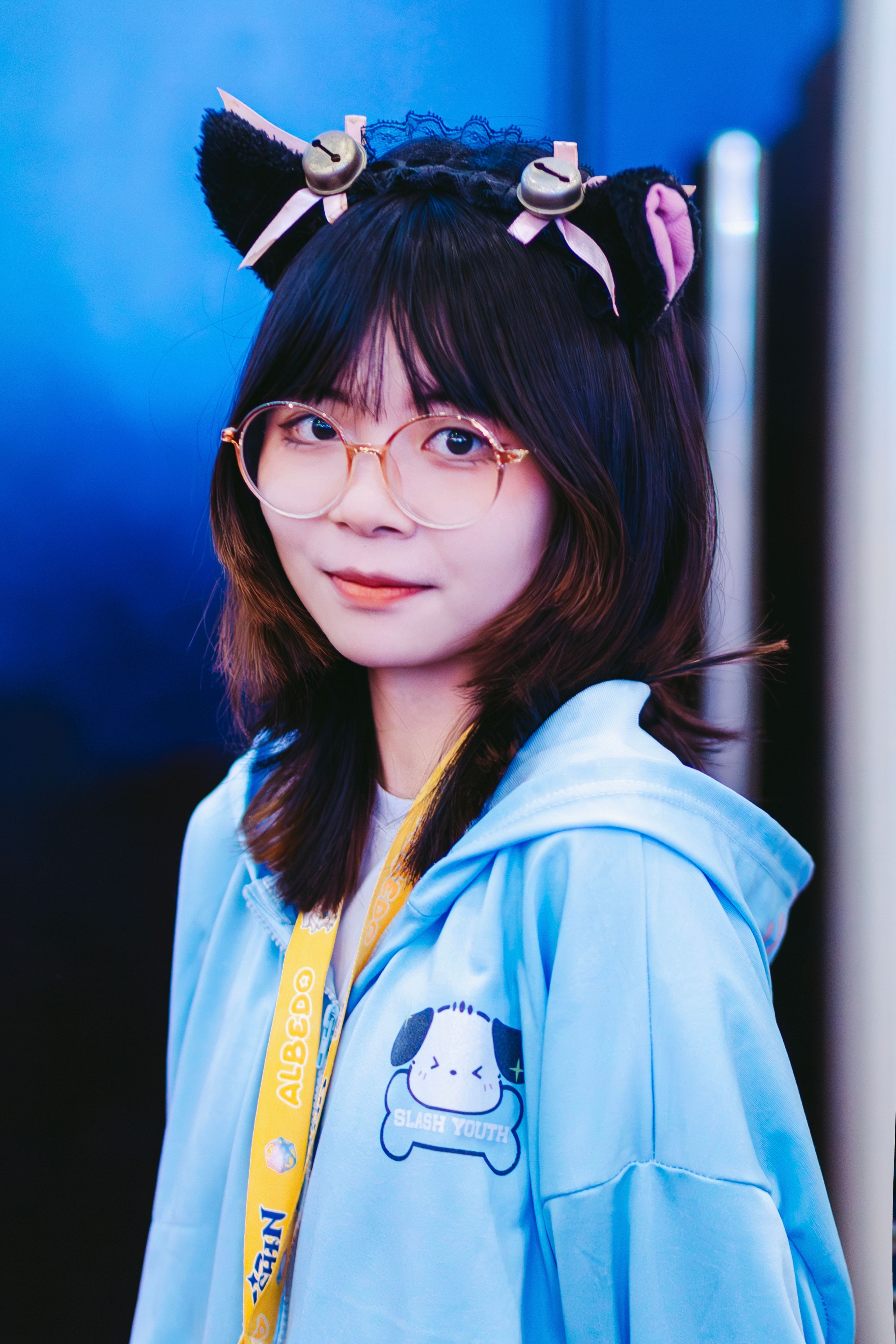 Charming portrait of a young woman wearing cat ear accessories indoors.