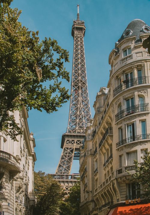 Free Stunning view of the Eiffel Tower framed by elegant Parisian buildings under a clear blue sky. Stock Photo