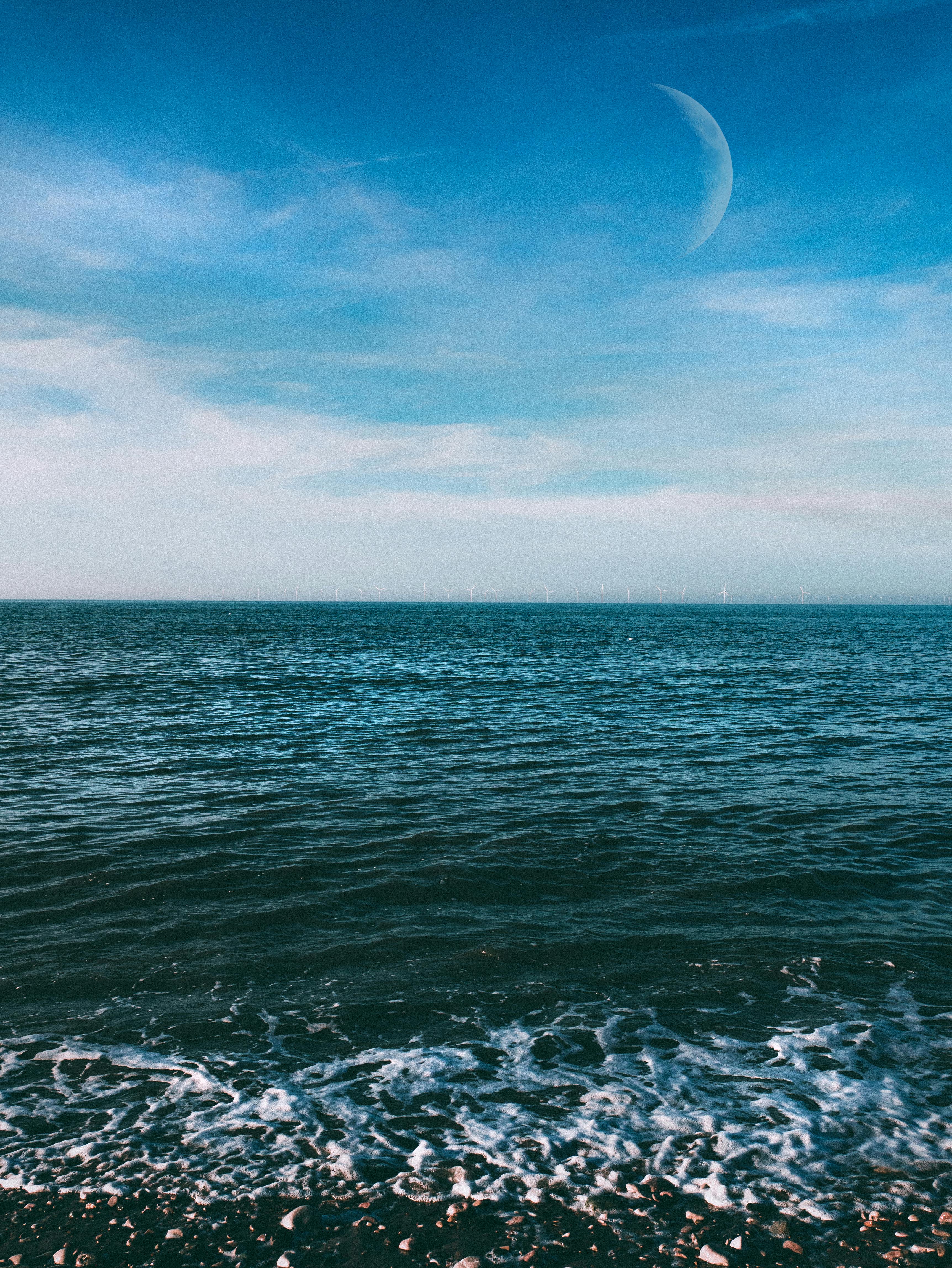 宁静的海景，月亮映照在平静的海面上，非常适合激发旅行灵感