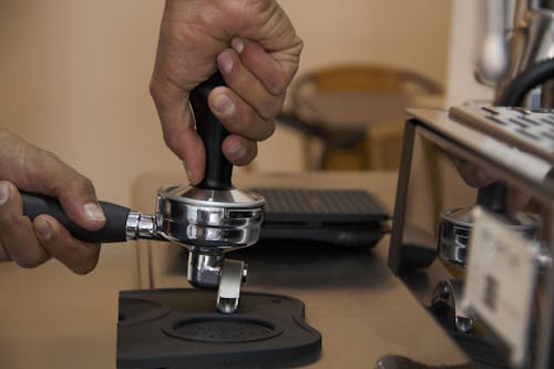Close-up of a Barista Using a Coffee Tamper 