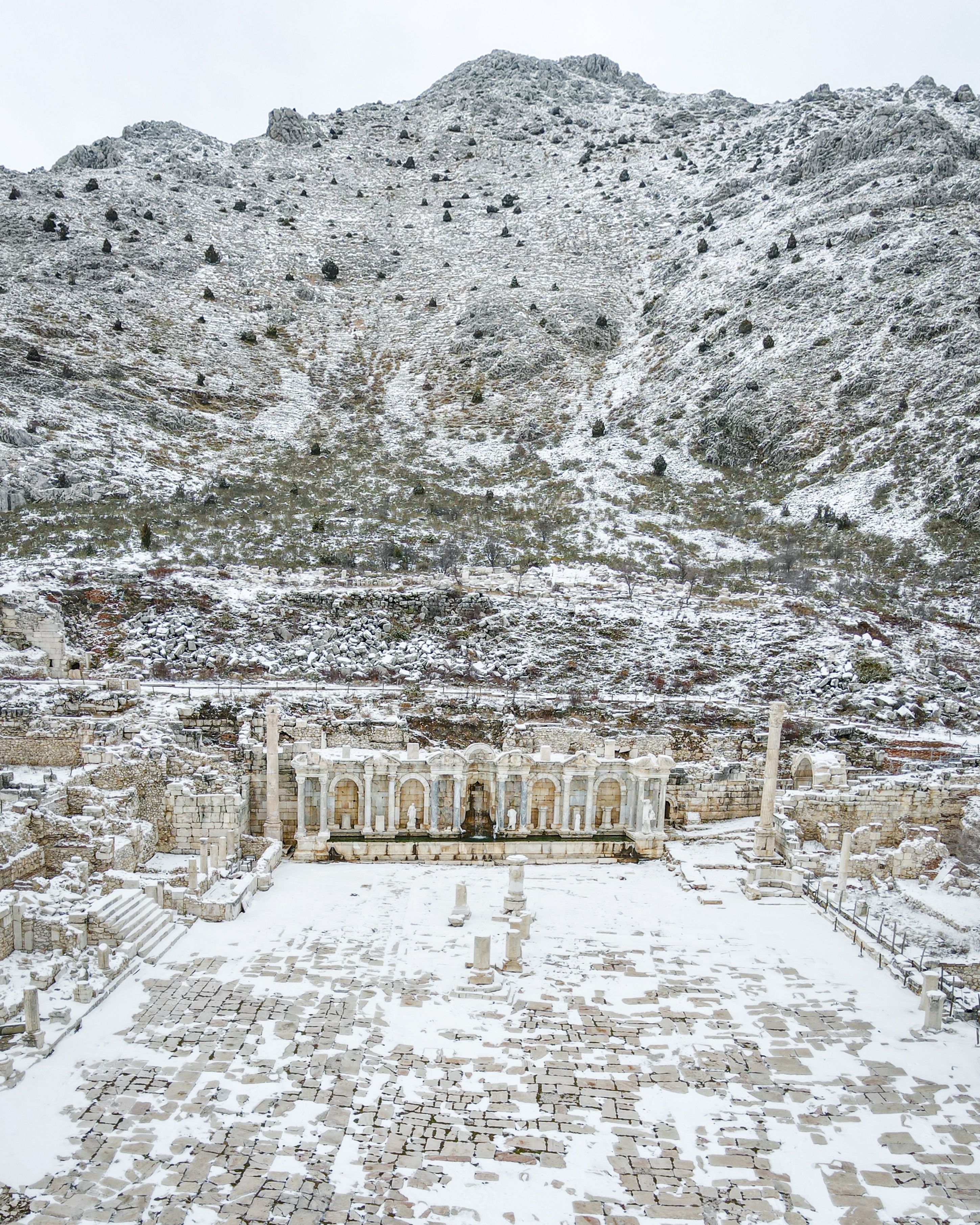 Stunning snow-covered ancient ruins in Burdur, Türkiye, showcasing winter beauty.