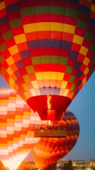 Colorful hot air balloons soaring over Türkiye's landscape at sunrise, showcasing vibrant designs and scenic views.