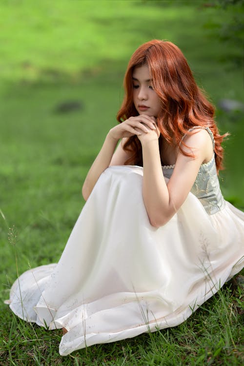 Redhead Woman Sitting in White Dress