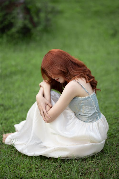 A Redhead Woman Sitting on Grass