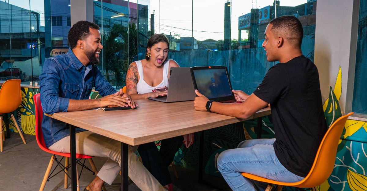 diverse group of people collaborating on laptops in a cozy, modern co-working space