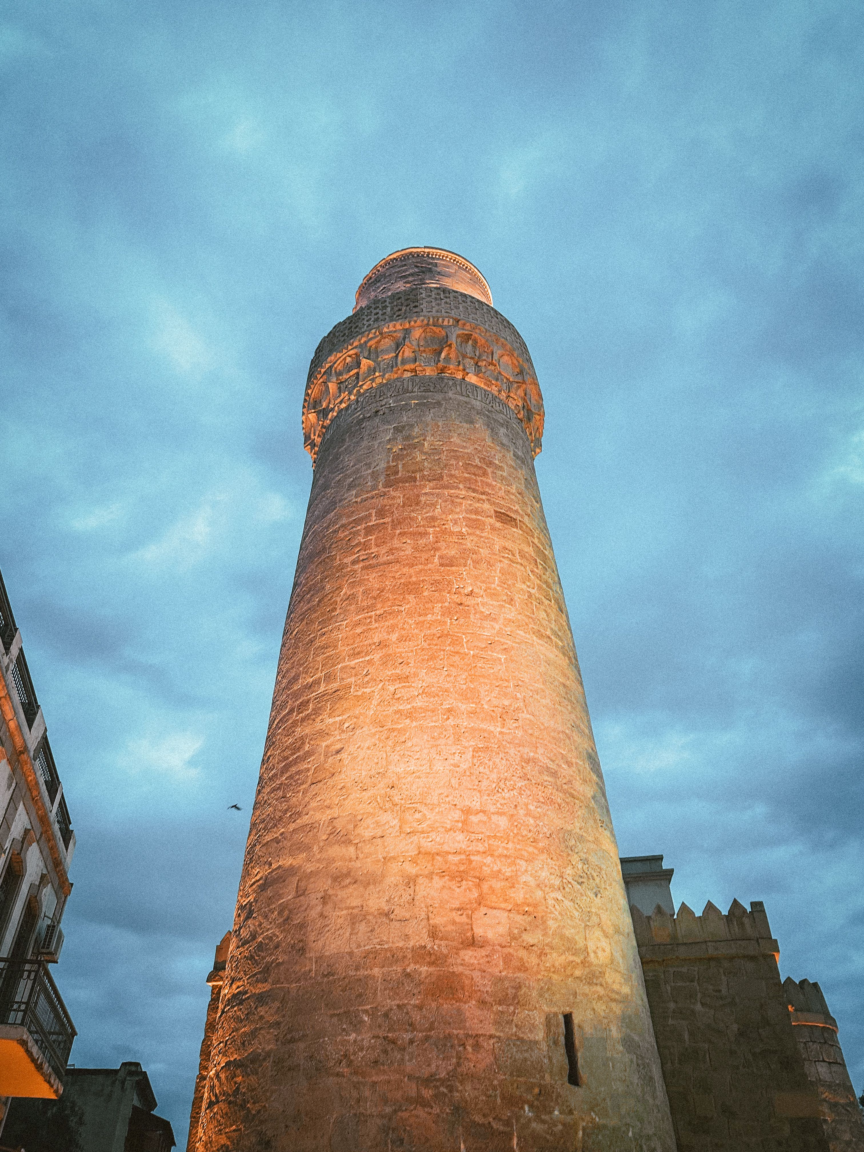 A striking view of Muhammad Mosque's minaret, illuminated against the dusky sky in Baku, Azerbaijan.