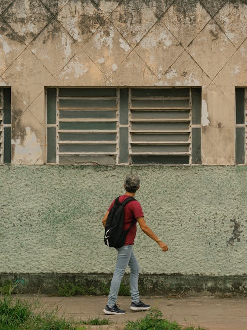 A Man Walking by an Abandoned Building