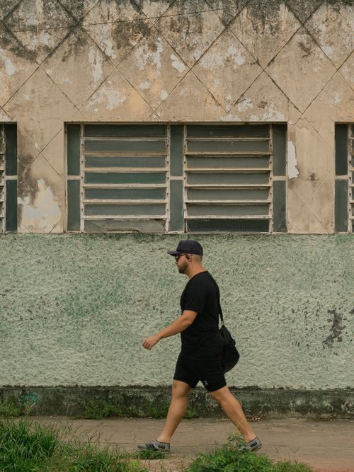 Free A man in black walks past a weathered building in Carpina, Brazil. Stock Photo