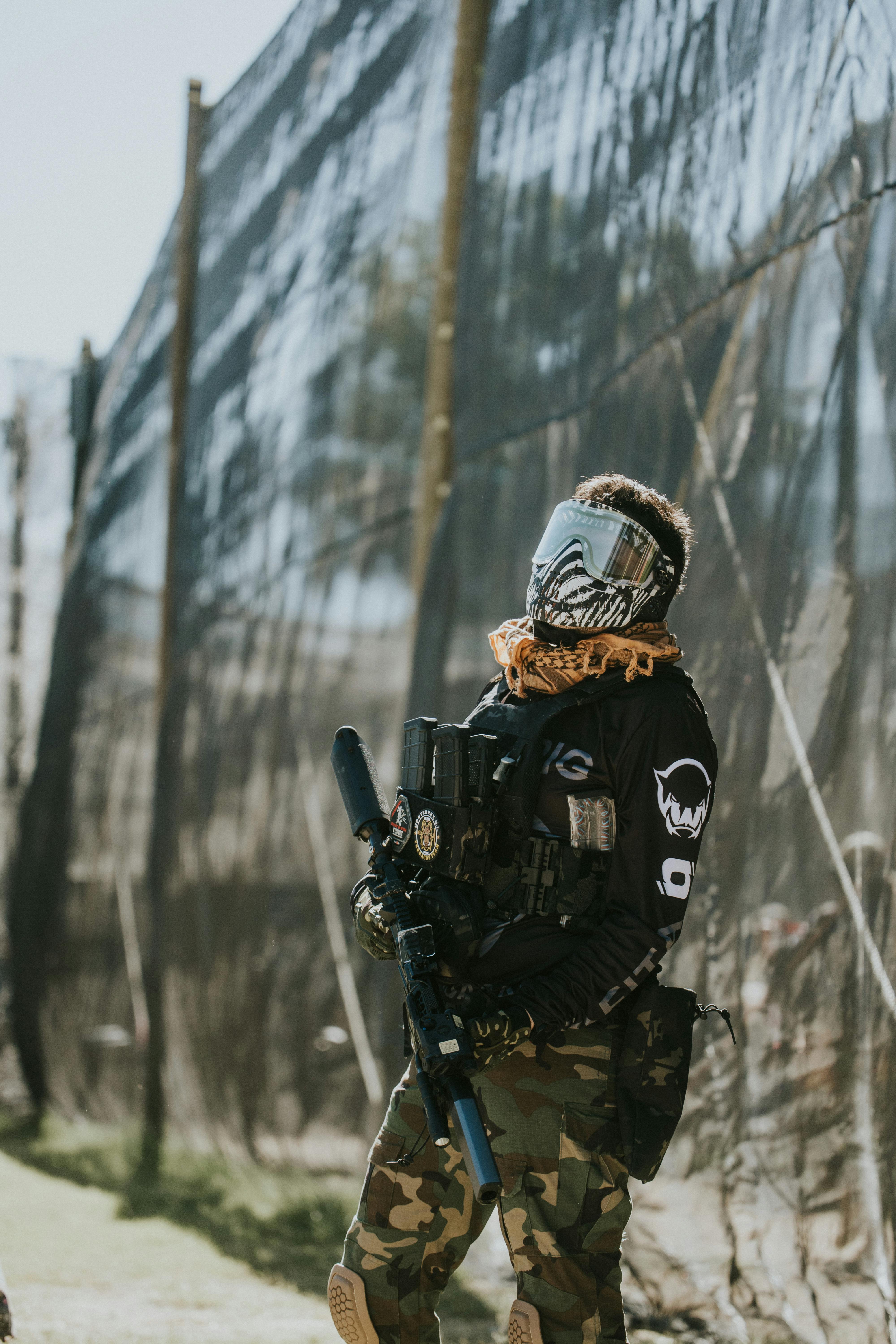 Paintballspieler in voller Montur steht im Freien, bereit zum Einsatz. Prescription Goggle Inserts - Paintball player in full gear standing outdoors, ready for action.