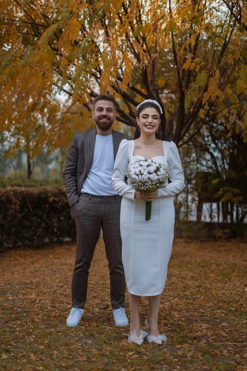 Smiling Newlyweds in Park in Autumn