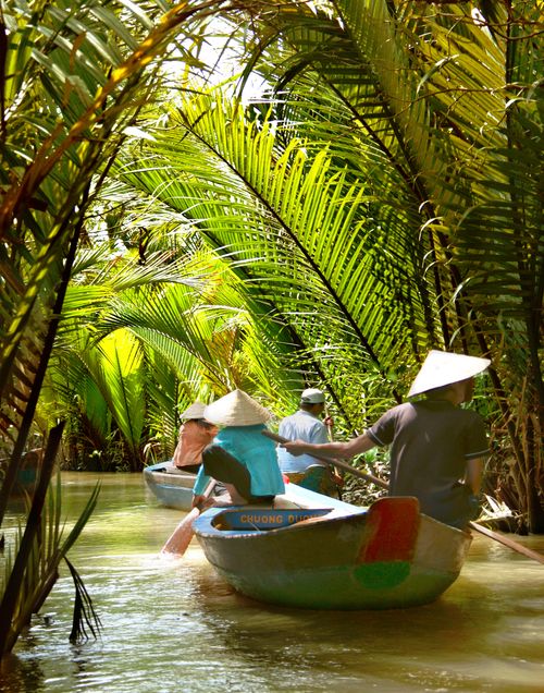 Free Experience a serene riverboat journey through lush tropical palms in Ho Chi Minh City, Vietnam. Stock Photo