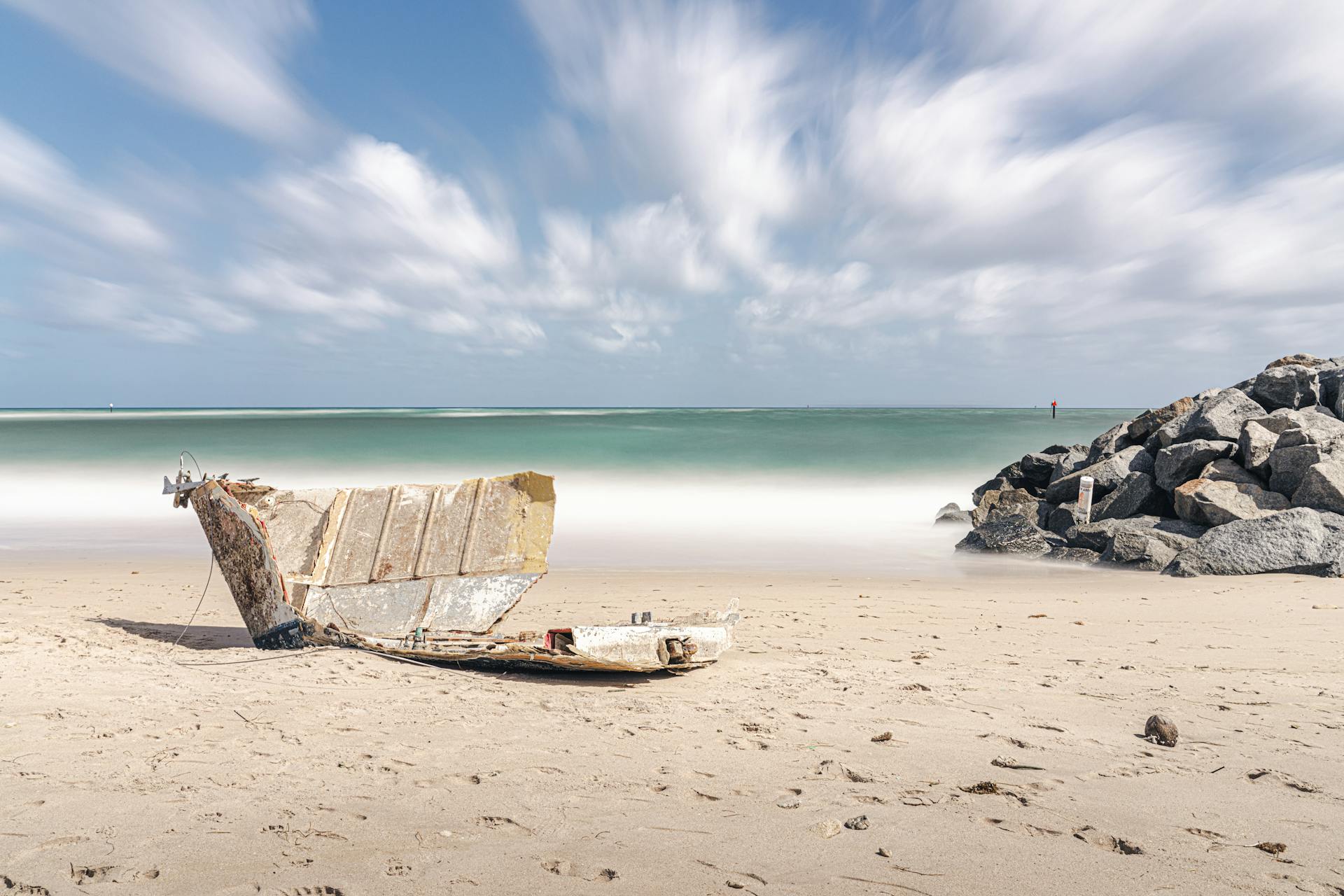 Serene Miami beach view with boat remains on sand and distant horizon.
