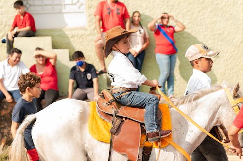 Small Boy in a Cowboy Hat Riding a Horse